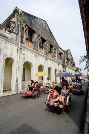 George Town, Penang/Malaysia - Aug 07 2016: Rickshaw with passenger on street with old heritage building at background.のeditorial素材
