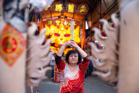 Bukit Mertajam, Penang/Malaysia - Aug 19 2016: Chinese woman pray with burn joss stick during hungry ghost festival.のeditorial素材