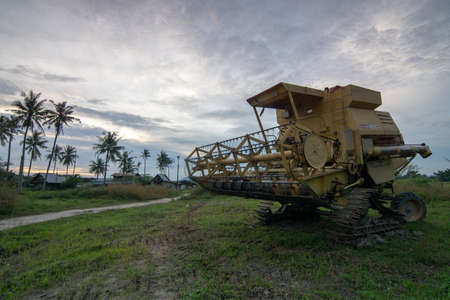 Bukit Mertajam, Penang/Malaysia - Jan 06 2017: Harvester in evening at scenic green field.