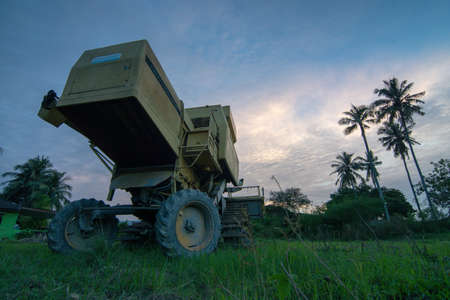 Bukit Mertajam, Penang/Malaysia - Jan 06 2017: Low angle harvester park in field during sunset.のeditorial素材