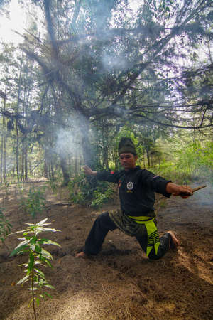 Kelantan/Malaysia - Jul 15 2017: Silat art master practice in fog jungle.のeditorial素材