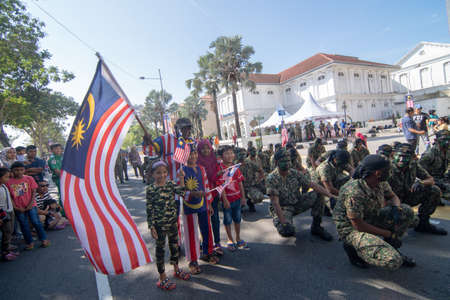George Town, Penang/Malaysia - Aug 31 2017: Patriotic Malaysia wave Malaysia flag beside soldier.のeditorial素材