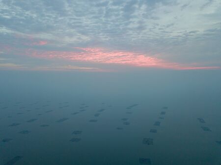 Aerial view sunset at fish farm at sea near Penang Second Bridge in dramatic sunset.の写真素材