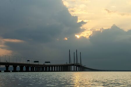 Sun rise through the cloud at Penang second bridge in morning.の写真素材