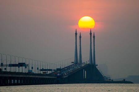 Egg yolk sunrise at Penang Bridge during hazy morning.の素材 [FY310142899280]