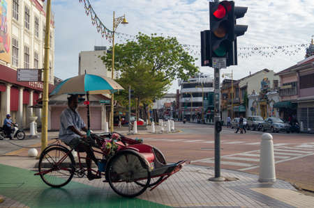 Georgetown, Penang/Malaysia - Feb 14 2020: Rickshaw driver wait at traffic lightのeditorial素材