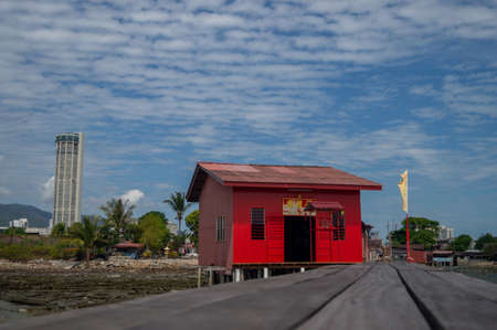 Georgetown, Penang/Malaysia - Feb 14 2020: Red old chinese temple at Tan Jetty with background KOMTAR building.のeditorial素材