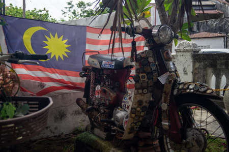 Georgetown, Penang/Malaysia - Feb 14 2020: A Malaysia flag at the back of vintage motorcycle.のeditorial素材