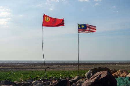 Pulau Ssyak, Kedah/Malaysia - Feb 26 2020: Malaysia and Kedah flag waving near outdoor.のeditorial素材