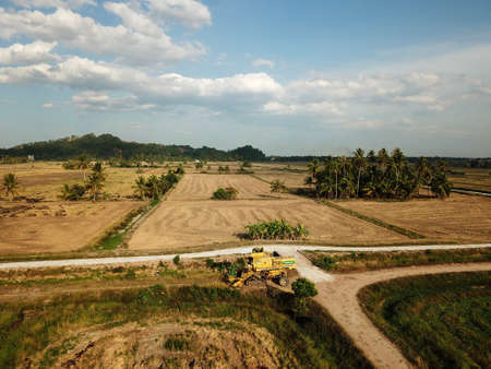 Pulau Ssyak, Kedah/Malaysia - Feb 26 2020: Harvester and rice paddy field in evening.のeditorial素材