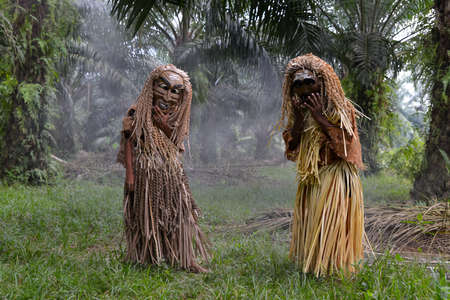 Carey Island, Selangor/Malaysia - Mar 17 2018: Malaysia's indigenous tribesmen wear mask in oil palm estate.のeditorial素材
