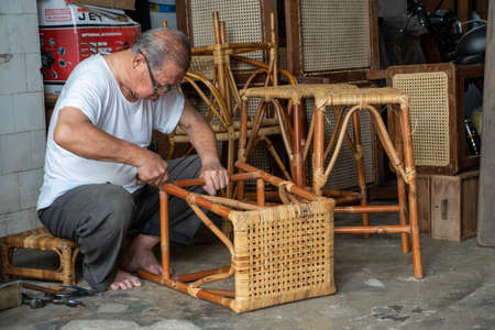 George Town, Penang/Malaysia - Jul 19 2018: A man repair ratten chair.のeditorial素材