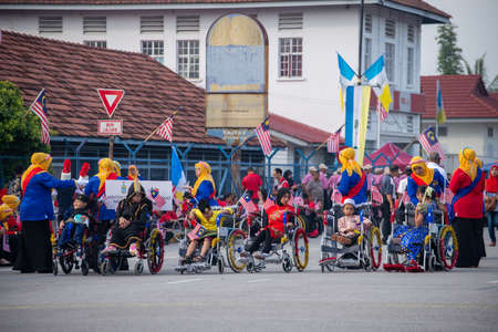 Butterworth, Penang/Malaysia - Aug 31 2019: Kids in wheel chair join Merdeka parade at street.のeditorial素材