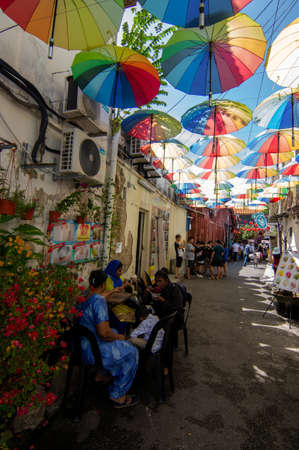 George Town, Penang/Malaysia - Nov 11 2019: A family have rest at the street with colorful umbrella.のeditorial素材
