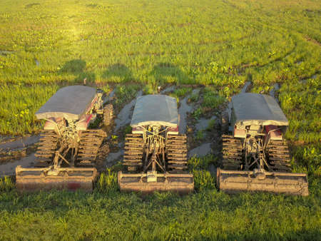Three tractors park in a row at paddy field. Malaysia main agriculture.の写真素材