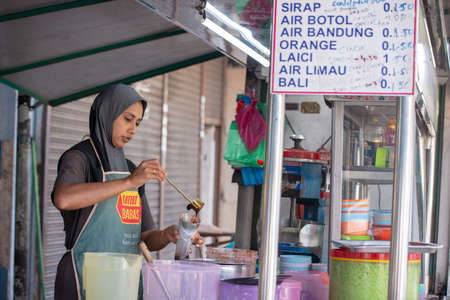 Bukit Mertajam, Penang/Malaysia - May 26 2019: Cendol seller prepare the beverage at stall.