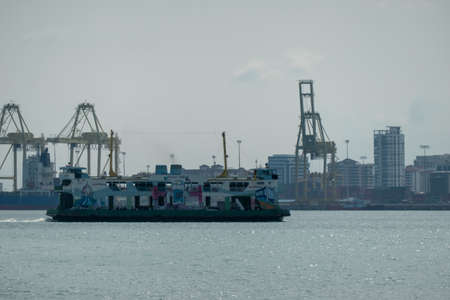Georgetown, Penang/Malaysia - Sep 25 2020: Rapid ferry move at Penang sea. Background is container terminal.のeditorial素材