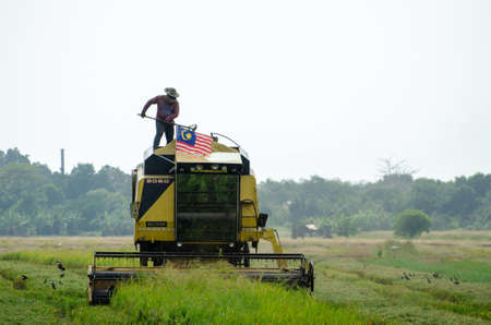 Georgetown, Penang/Malaysia - Aug 29 2020: Local Malays stand at the harvester adjust the level of...