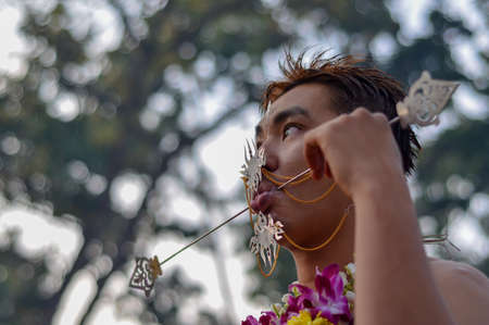 Georgetown, Penang/Malaysia - Jan 17 2014: Cheeks pierced by chinese devotee during Thaipusam.