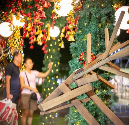 Selective focus wooden deer shape decoration. Background is couple selfie with shopping bag. Consumerism holiday conceptの写真素材
