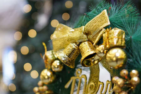Close up gold Christmas bell ornament at Christmas Tree