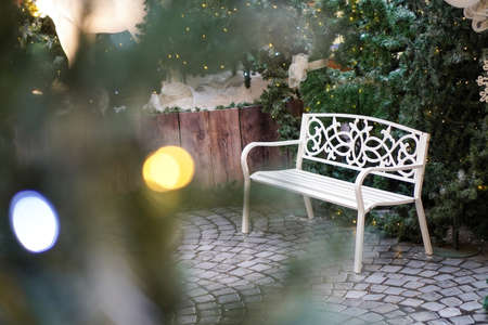 White bench with the foreground blur bokeh. Christmas, winter holiday conceptの写真素材
