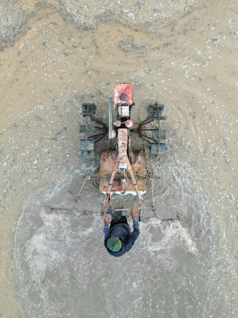 Aerial top down view farmer use tractor to plowing paddy fieldの写真素材