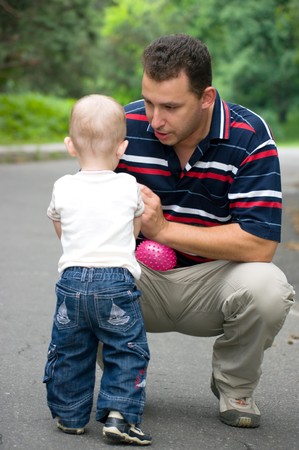 A man talking to a boy while sitting in the squatting positionの写真素材