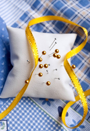 Needle cushion with pins in it set on cotton clothの写真素材