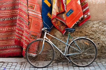 Old bicycle and traditional carpets on the street of Marrakesh, Moroccoの写真素材