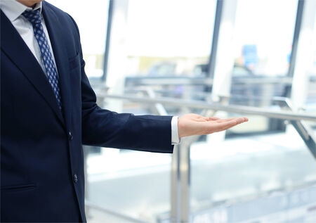 Handsome business man presenting with hand の写真素材