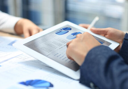 Image of human hand pointing at touchscreen in working environment at meeting 