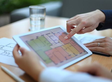 Real-estate agent showing house plans on electronic tablet