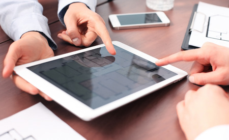 Real-estate agent showing house plans on electronic tablet