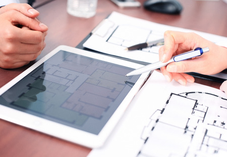 Real-estate agent showing house plans on electronic tabletの写真素材