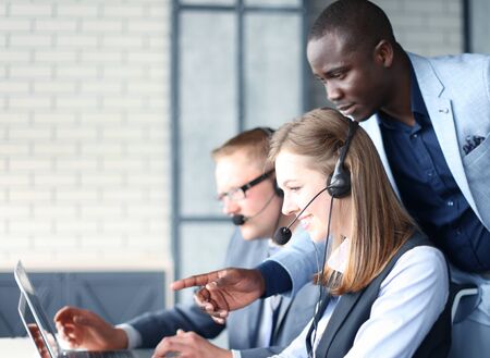 Phone operator working at call centre office helping hiss colleague