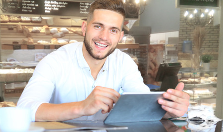 Small business owner working at his cafeの写真素材