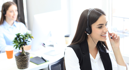 Attractive positive young businesspeople and colleagues in a call center office.の写真素材