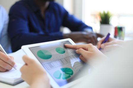 Business person analyzing financial statistics displayed on the tablet screen.の写真素材
