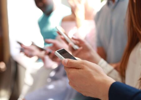 Group of students watching smartphones. Young people addiction to new technology trends.の写真素材