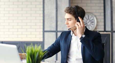 Smiling friendly handsome young male call centre operator.の写真素材
