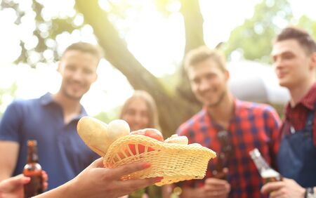 Group of friends making barbecue in the nature. Focus on the plate with eat.の写真素材