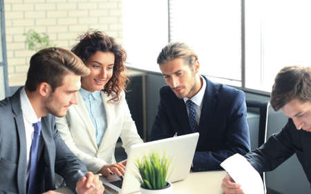 Startup business team on meeting in modern bright office interior and working on laptop