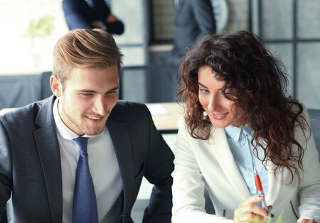 Startup business team on meeting in modern bright office interior and working on laptop