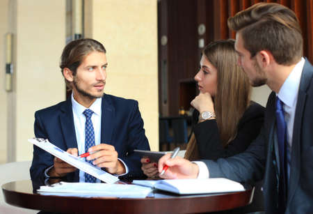 Business partners discussing documents and ideas at meeting
