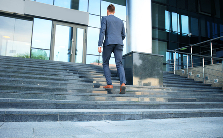 Business executive with briefcase going up the stairs.の写真素材