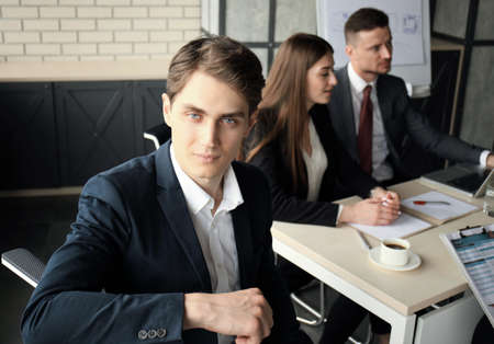 Businessman with colleagues in the background in office.の写真素材