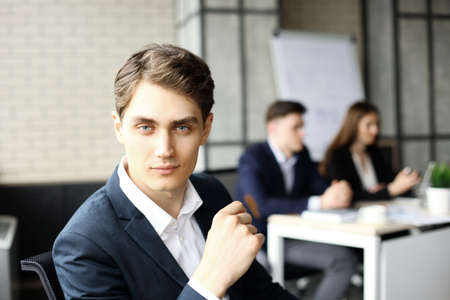 Businessman with colleagues in the background in office.の写真素材