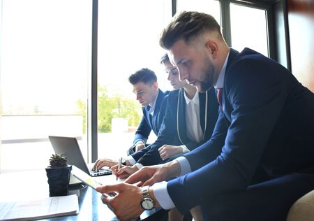 startup business team on meeting in modern bright office interior brainstorming, working on laptop...