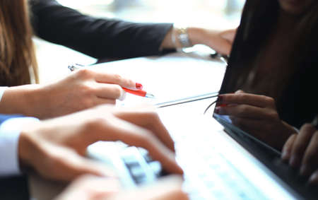 Business partners working together at office desk, they are using a laptop.